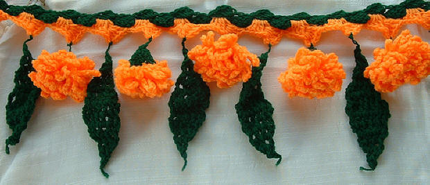Knitted toran simulating marigolds and mango leaves