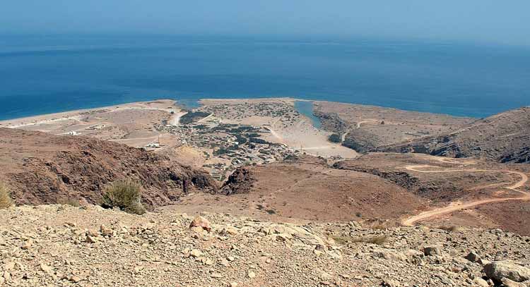A view of Qalhat village in the centre and the historic site seen to centre-right to the right of the lagoon