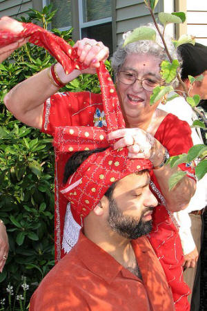 Bride's mother ties turban on son