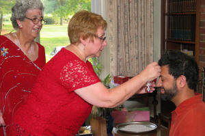 Preparing to officiate the madhavsaro. Groom's mother places a tila
