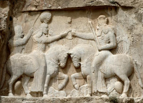 Investiture of Ardeshir I (224/6-241 CE), founder of the Sassanian dynasty Ardeshir receives the ring of kingship (farshiang/cydaris) from an individual carrying a barsom - likely a priest (magus) or senior family member.
