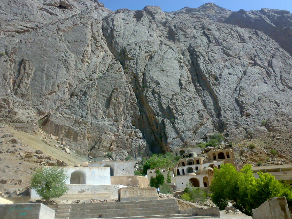 Pir-e Naraki in the shadow of the cliff face of Mount Naraki